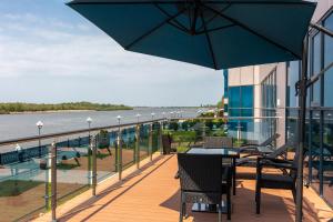 a balcony with a table and chairs and an umbrella at Grand Hotel Astrakhan in Astrakhan