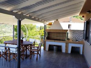 a patio with a table and a fireplace at Pure Blue in Athani