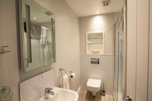 a bathroom with a sink and a toilet and a shower at The Kinderton in Middlewich