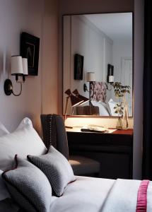 a bedroom with a bed and a desk and a mirror at Old Parsonage Hotel in Oxford