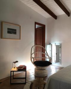 una habitación con una silla y una mesa con una lámpara en Casa Aldomar, en Xàtiva