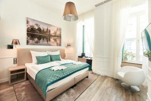 a white bedroom with a bed and a chair at Boutique Residence Budapest in Budapest