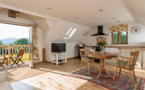 a kitchen and dining room with a table and a balcony at Rhiastyn Barn in Hyssington