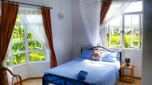 a bedroom with a bed and a large window at Surf House in La Gaulette