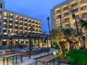 a hotel with tables and chairs in front of a building at Hotel Paradiso Garden in Playa de Palma