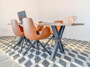 a table with orange chairs and a laptop on it at Hotel Paradiso Garden in Playa de Palma