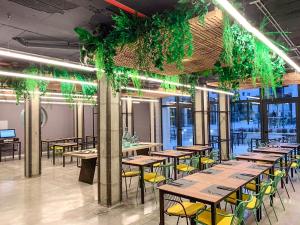 a row of tables and chairs in a room with plants at Hotel Paradiso Garden in Playa de Palma