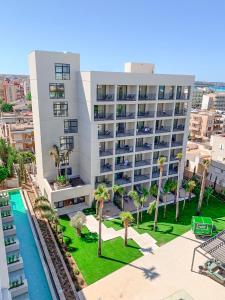 an aerial view of a building with a pool and palm trees at Hotel Paradiso Garden in Playa de Palma