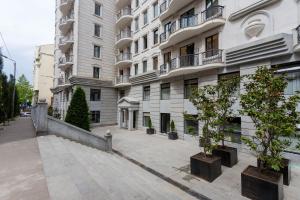 a building with potted trees in front of it at Serviced Apartment on Rustaveli Avenue in Tbilisi City