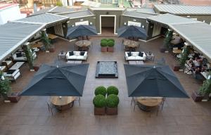 widok na patio ze stołami i parasolami w obiekcie Hotel Granvia w Barcelonie
