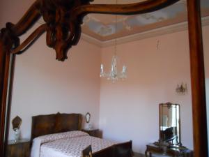 una camera da letto con un letto e uno specchio di Borgo Due Mari a Taranto
