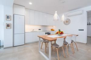 a kitchen with white cabinets and a wooden table and chairs at Ca Na Foc in Sa Pobla