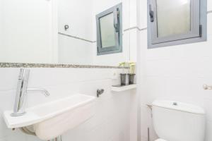 ein weißes Badezimmer mit Waschbecken und Toilette in der Unterkunft Can Munar in Son Serra de Marina + 19 Fotos