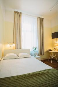 a bedroom with a large white bed with a window at Economy Hotel in Tallinn