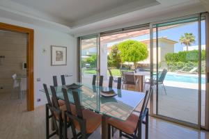 a dining room with a glass table and chairs at Villa Agusmar in Cala Blava