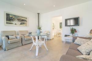 ein Wohnzimmer mit einem Tisch und einem Sofa in der Unterkunft Can Munar in Son Serra de Marina
