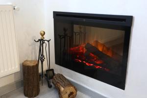 a fireplace against a white wall with a fire at Simona Maria 2 in Bucharest