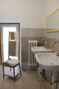 a bathroom with a sink and a mirror and a chair at Il Viterbino Struttura convenzionata con impianti termali in Viterbo