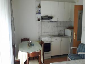 a small kitchen with a table and a table and a sink at Apartments Kate - 20m from the beach in Brist