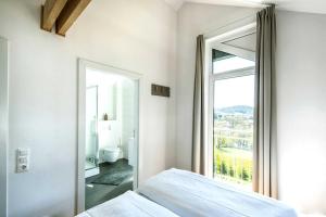 ein Schlafzimmer mit einem Bett und einem großen Fenster in der Unterkunft Panoramabungalow (70) im Feriendorf an der Therme Obernsees in Truppach