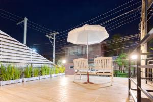 - deux chaises et un parasol sur le balcon la nuit dans l'établissement Baan Pak Hadd Jao Sea Wind2, à Haad Chao Samran
