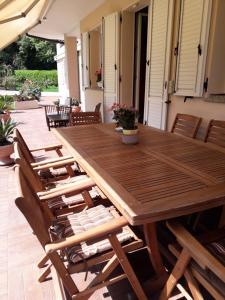 uma mesa de madeira e cadeiras num pátio em Villa Fabbri em Gradara