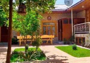 a house with a bench in the front yard at Marhabo Guesthouse in Samarkand