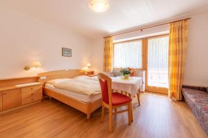 una camera con letto, tavolo e divano di Residence Trenker Luis a Braies (Prags)