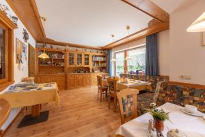 un ristorante con tavoli e sedie in una stanza di Residence Trenker Luis a Braies (Prags)
