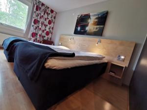 1 dormitorio con 1 cama con cabecero de madera en RastPunkt Laxå, en Laxå
