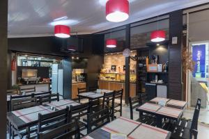 a restaurant with tables and chairs and red lights at Rezende Suítes Hotel in Balneário Camboriú