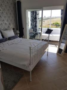 een slaapkamer met een bed en uitzicht op een patio bij Marina Golf, Tanger Emplacement supérieur Juste à côté de la piscine in Asilah