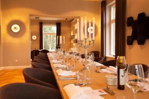a long table in a room with chairs and wine glasses at Villa Glanzstoff in Heinsberg