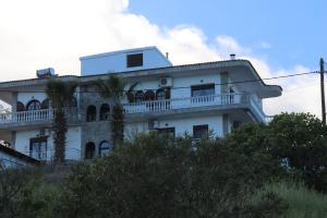 a white building with a balcony on a hill at Kalntera in Ammouliani