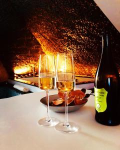 due bicchieri di vino bianco accanto a una bottiglia di vino di SuiteFrattini Private Spa a Roma