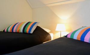 ein Schlafzimmer mit 2 Betten mit gestreiften Kissen und einer Lampe in der Unterkunft Antibes 200- Kustpark Village Scaldia in Hoofdplaat