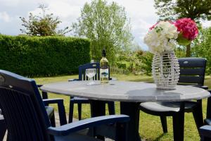 ein Tisch mit einer Flasche Wein und einer Vase mit Blumen in der Unterkunft Antibes 200- Kustpark Village Scaldia in Hoofdplaat