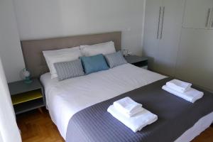 アテネにあるDeluxe Apartment in Vouliagmeniのベッドルーム1室(大型ベッド1台、タオル付)