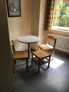 uma mesa e cadeiras num quarto com uma mesa e cadeiras em Jugendherberge Göttingen em Göttingen