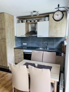 a kitchen with a table and chairs and a clock at Drei Zimmer Apartment am Rhein in Bad Säckingen