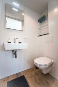 een witte badkamer met een wastafel en een toilet bij Studio 4 U in Zandvoort