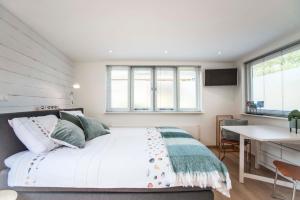 een slaapkamer met een groot bed en een bureau bij Studio 4 U in Zandvoort