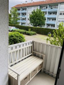 a white bench sitting on the balcony of a building at Drei Zimmer Apartment am Rhein in Bad Säckingen +7 photos