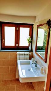 a bathroom with a white sink and two windows at La Quercia di Aorivola in Caianello Vecchio