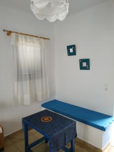 a blue bench in a room with a table at Venetiko Studios in Irakleia
