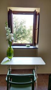 a table with a vase of flowers and a window at La Quercia di Aorivola in Caianello Vecchio