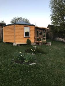 a small wooden cabin in a yard with flowers at Sillaotsa camp in Paide