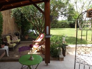 een patio met een stoel, een tafel en een poort bij Côté Sud in Sarlat-la-Canéda
