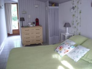 een slaapkamer met een groen bed en een dressoir met een lamp bij Côté Sud in Sarlat-la-Canéda