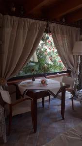 einen Tisch und Stühle in einem Zimmer mit Fenster in der Unterkunft Villa dei giardini in San Leone